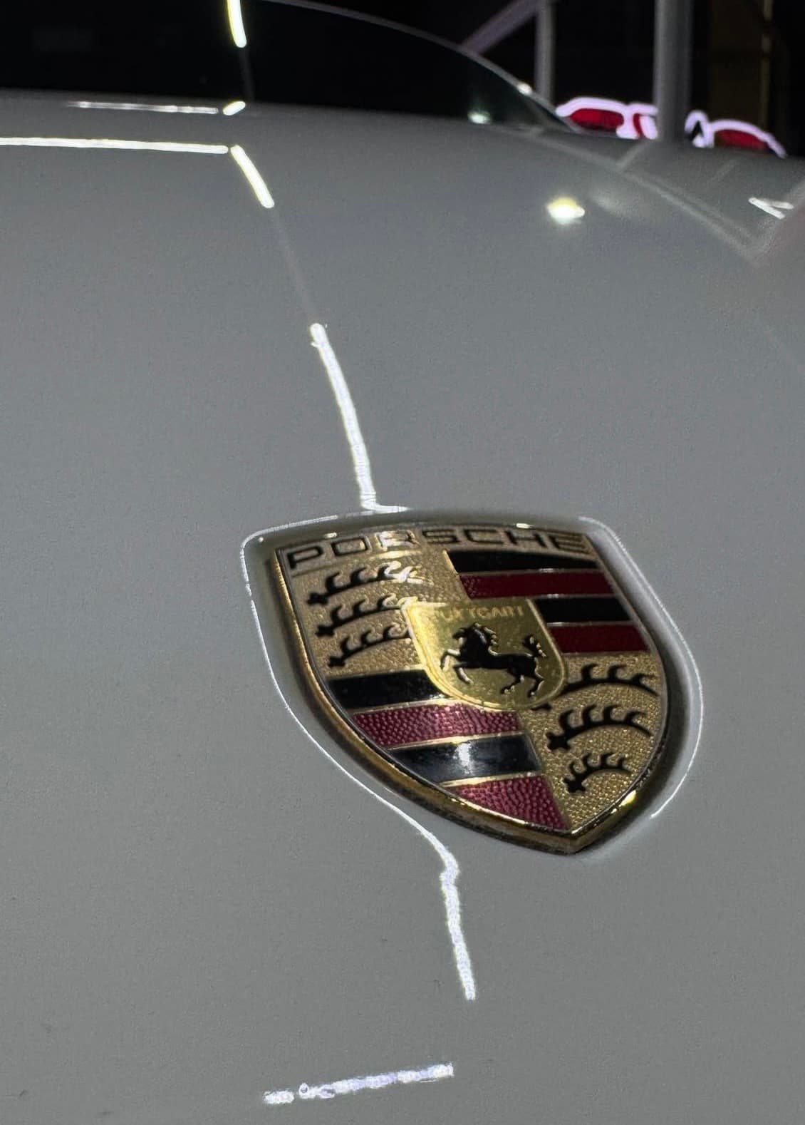Emblema Porsche sobre pintura recién pulida