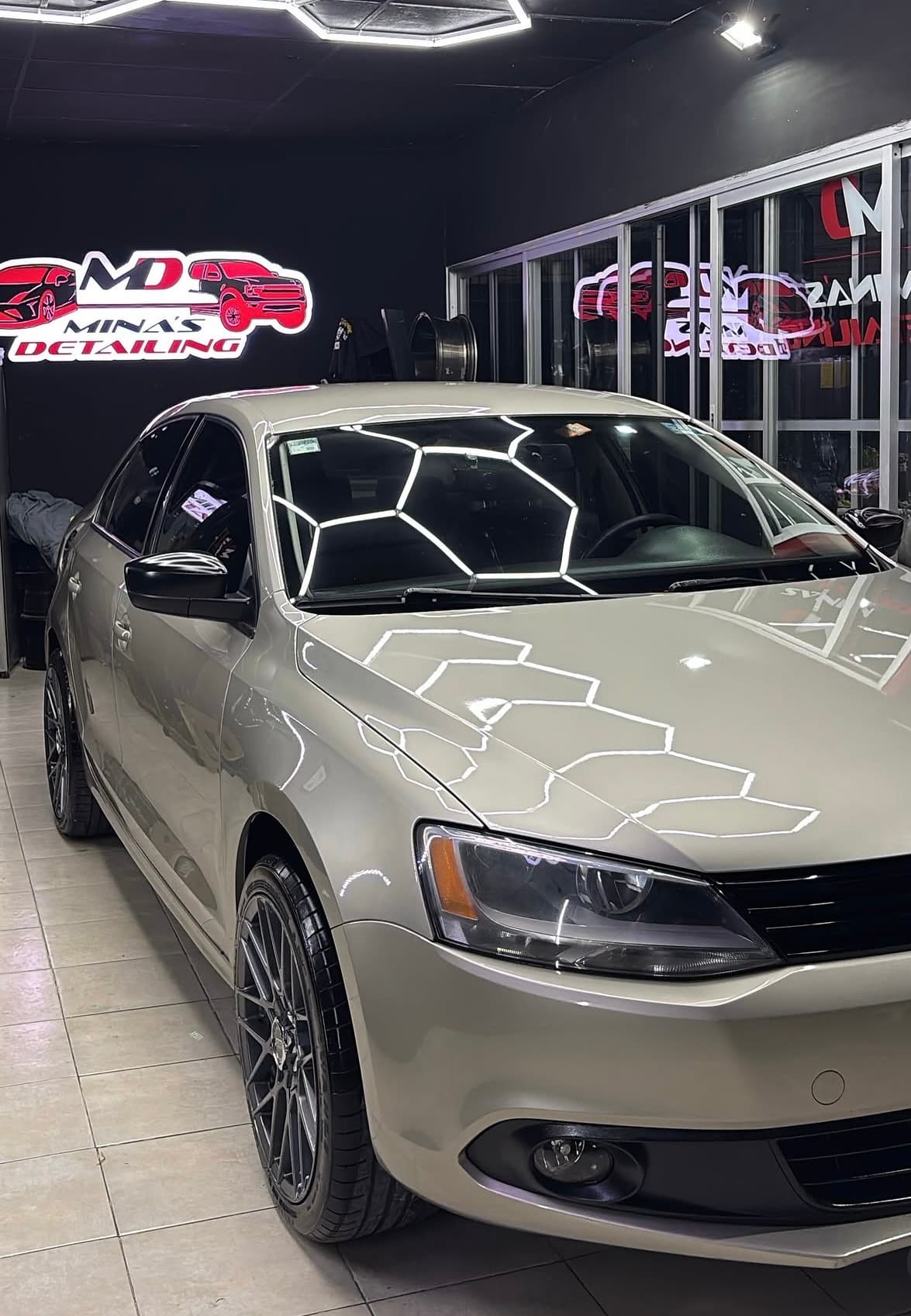Volkswagen Jetta terminado frente al letrero de Minas Detailing